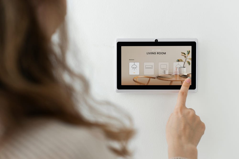 Woman pressing on smart home automation panel monitor.