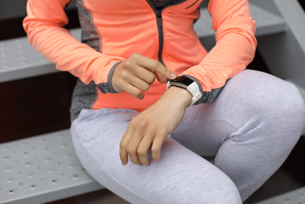 Female athlete using a fitness tracker.