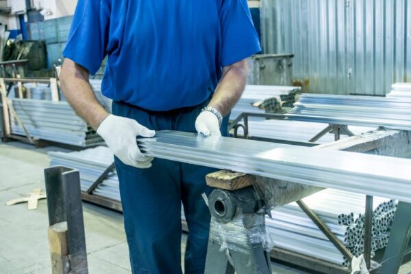 The world of extrusions shown with different extruding machines - The World of Extrusions: Different Types, Advantages, Disadvantages and Which Is Right for Your Business - Viking Extrusions aluminium extrusions being handled in warehouse