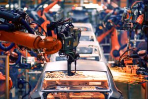 Automobile assembly line production showing the chassis of cars being put together.