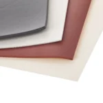 The corner of a pile of different coloured general purpose silicone sponge sheets.